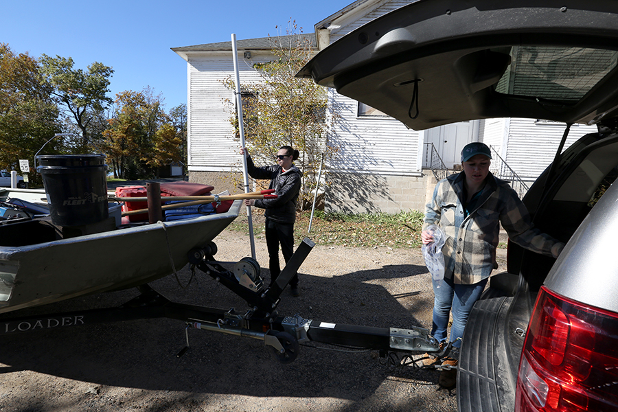 Conor Dougherty, at left, who works at CLRR, and Heidi Lieffort, associate research specialist with CLRR, prepare to load a research boat into Cedar Lake in Star Prairie.