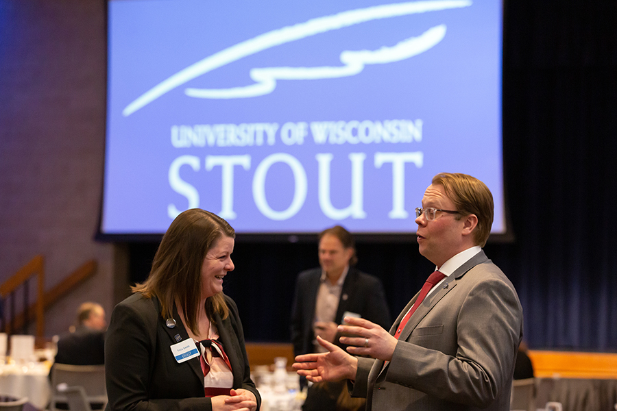 Eric Brey, professor and chair of the School of Hospitality Leadership, at right, shares a laugh during a celebration of the school.