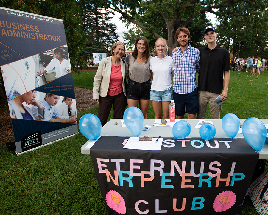 From left, Assistant Professor Mary Spaeth, Megan Nimsgern, Kayla Bolster and other members of the Entrepreneurship Club gather at the Backyard Bash student event on campus in September.