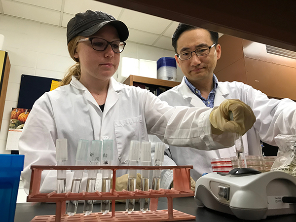 Lehmann works with Assistant Professor Taejo Kim in a food science lab at UW-Stout.