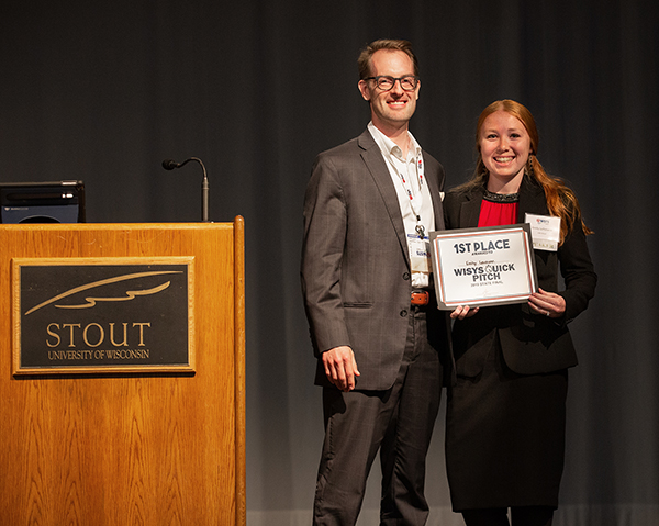Aaron Hagar, vice president of entrepreneurship and innovation for the Wisconsin Economic Development Corporation, presents Lehmann with the first prize in the WiSys Quick Pitch state final. WEDC sponsored the event.