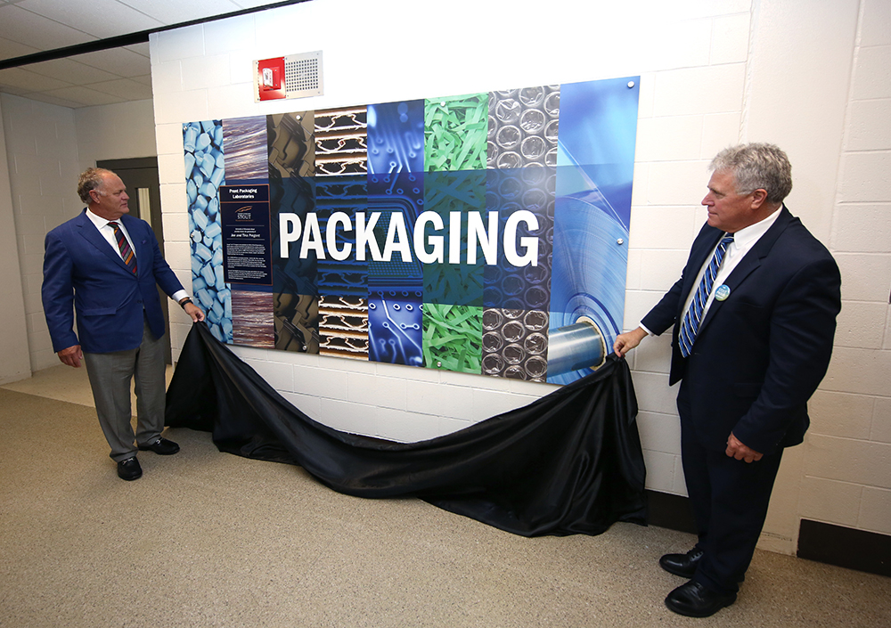 Joe Pregont and Chancellor Bob Meyer unveil the new sign for the Prent Packaging Laboratories.