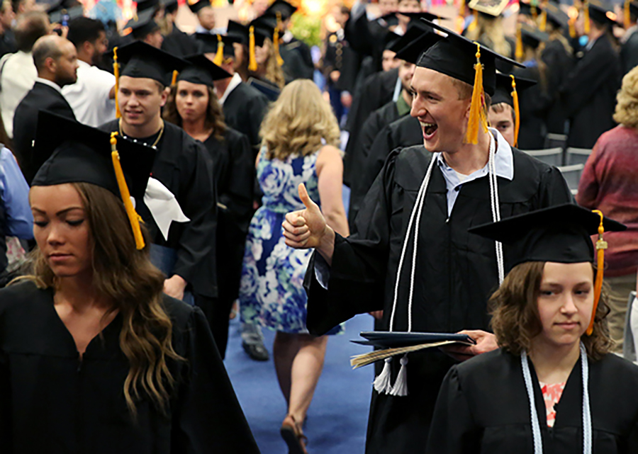 Nick Richards, right, celebrates in May 2018 after receiving his diploma. Richards, a manufacturing engineering graduate, works at Trystar in Faribault, Minn.