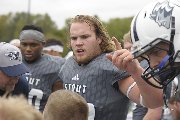 Aaron Wisecup, a semifinalist for a national student athlete award, talks with teammates during a 2018 UW-Stout football game.