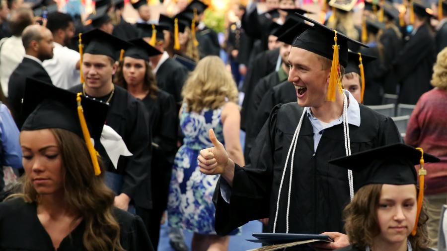 A happy Nick Richards, right, leaves Johnson Fieldhouse with his diploma May 5.