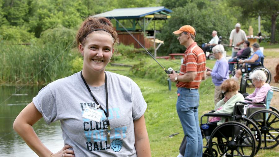 HDFS student Chelsea Lavold is a life enhancement intern with The Neighbors of Dunn County, a new model of non-institutional nursing homes in Menomonie, WI. Lavold is photographed working with residents during a fishing outing at Bullfrog Fish Farm.