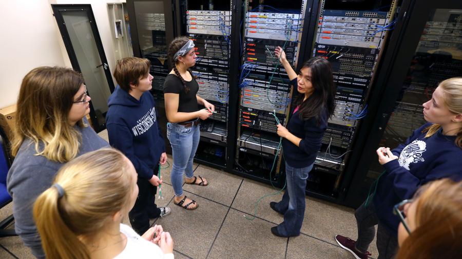 Professor Holly Yuan shows female CNIT students computer servers in a lab in Micheels Hall.