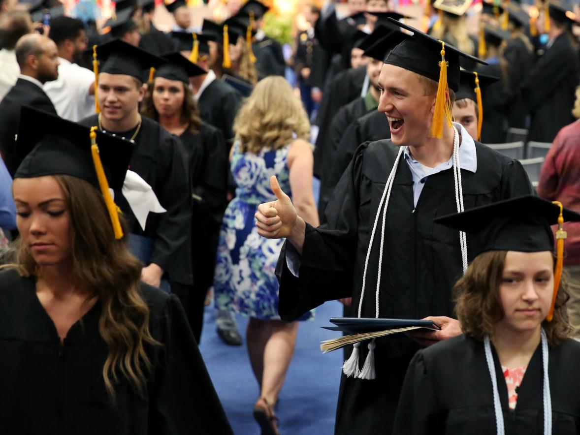 A happy Nick Richards, right, leaves Johnson Fieldhouse with his diploma May 5.
