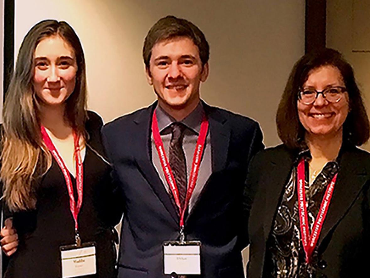 From left, UW-Stout students Maddie Kayser and Dylan Pass with Associate Professor Joan Navarre attend the national honors conference in November in Boston, where they gave a presentation.