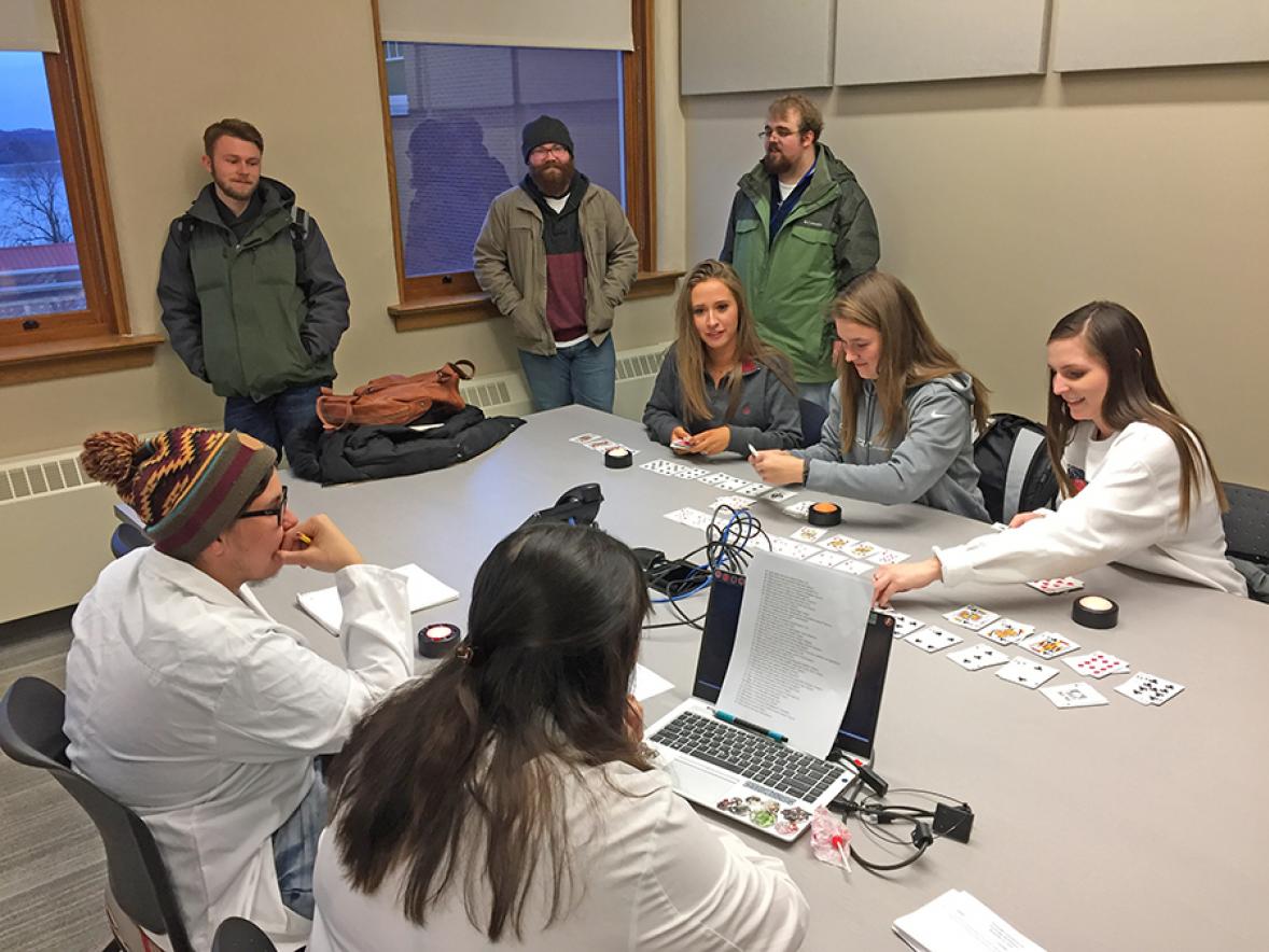 UW-Stout students Kaylee Sutliff, at left, Kate Peterson and Caitlin Solie attempt to multitask by sorting playing cards and answering questions at the same time during a psychology myth-busting event.