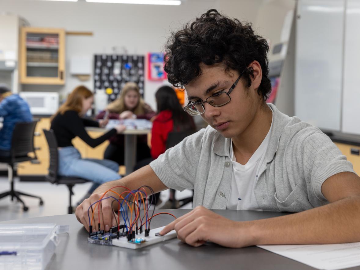 Upward Bound student in Stout science lab with circuit board