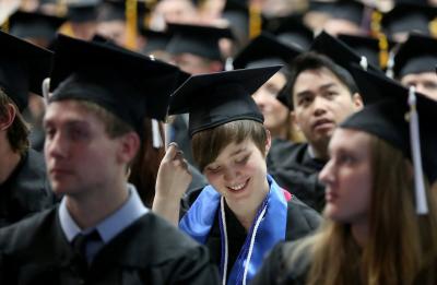 A UW-Stout graduate smiles while awaiting her diploma at Commencement.