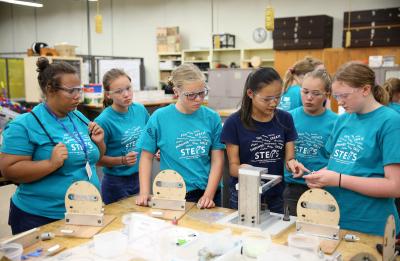 The annual STEPS for Girls camp is photographed Tuesday, July 17, 2018. Pictured is lab assistant Amber Knudson (third from right) assisting campers with the assembly of robots in a lab in Jarvis Hall Technology Wing, where participants experienced and learned about key manufacturing concepts and processes . (UW-Stout photo by Brett T. Roseman)