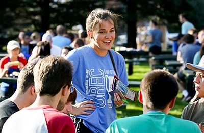 University Recreation student employee engages students at outdoor event.