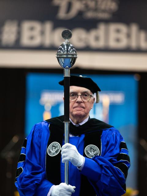 Hospitality Professor Phil McGuirk leads a faculty and staff procession into the fall 2019 commencement ceremony.