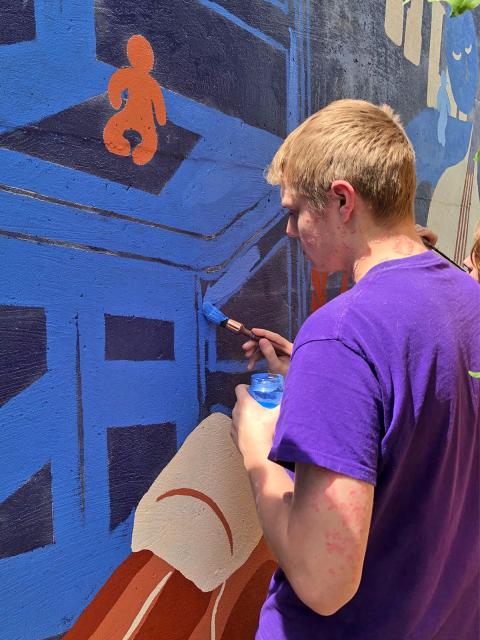 Graffiti and Street Art student Evan Mancl painting the mural